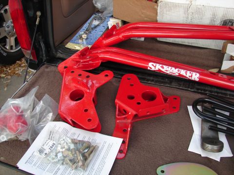 1996 Ford Bronco - Red Skyjacker suspension lift components and hardware kit are laid out on a carpeted surface.