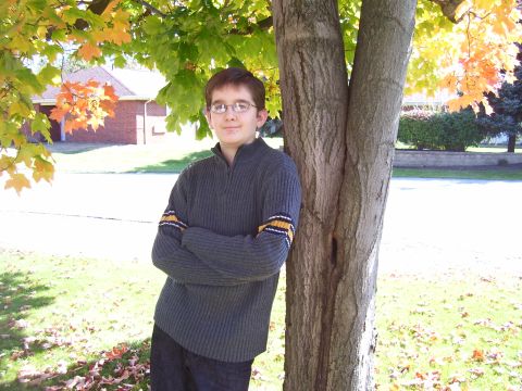 1993 Ford Bronco - A young person stands with arms crossed under autumn leaves.