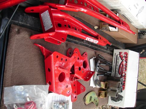 1996 Ford Bronco - Various red suspension lift parts and hardware are visible in this overhead shot.