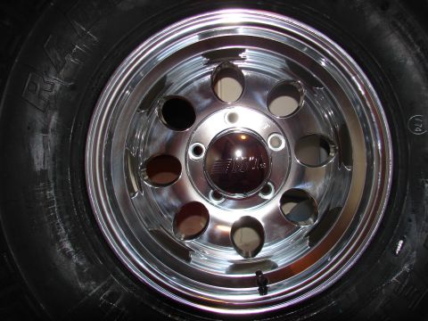 1996 Ford Bronco - Close-up of a chrome wheel and tire assembly, showing the brand name on the center cap.