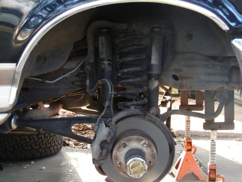 1996 Ford Bronco - Close-up of the front suspension and tire assembly on a 1996 Ford Bronco, indicating modifications for lift and larger tires.