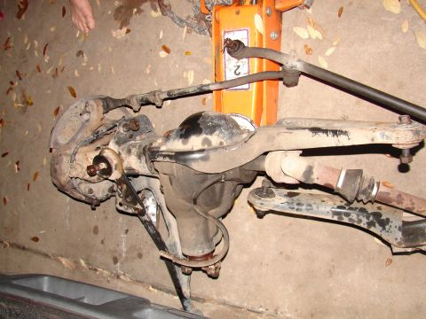 1996 Ford Bronco - Front axle and suspension components are shown, with a jack visible in the background.