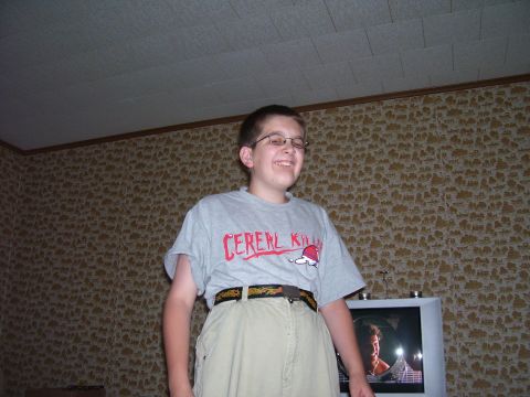 1993 Ford Bronco - Boy in a 'CEREAL KILLER' t-shirt stands in front of a patterned wall and a television.