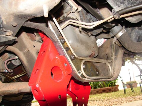 1996 Ford Bronco - Vehicle undercarriage detail, supported by red jack stands, with visible suspension and engine parts.