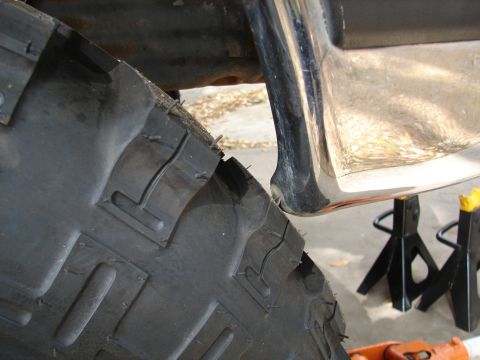 1996 Ford Bronco - A vehicle's large tire and chrome bumper are visible, supported by jack stands.