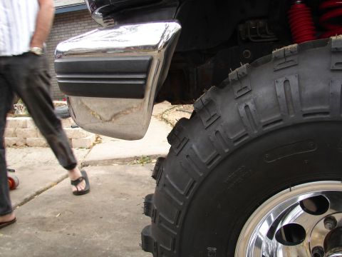 1996 Ford Bronco - Close-up of the rear chrome bumper and oversized tire on a 1996 Ford Bronco, highlighting its lifted suspension.