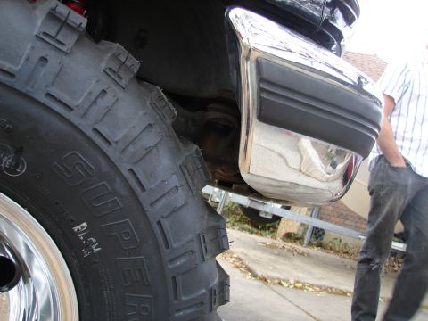1996 Ford Bronco - Detail shot of a large off-road tire and chrome bumper section.