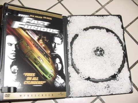 1997 Ford Crown Victoria - DVD case for The Fast and the Furious movie, filled with rice, on a tiled surface.