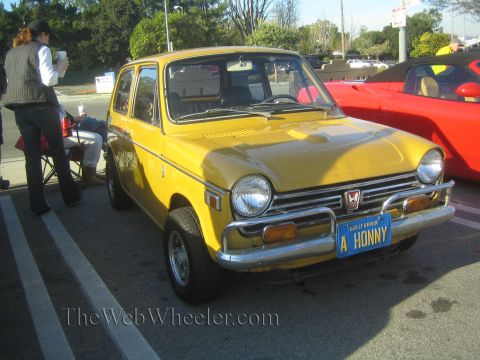 1985 Ford Mustang - A yellow Honda Z600 is parked next to a red sports car at an outdoor event.