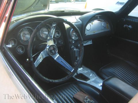 1985 Ford Mustang - Interior view of a 1963 Chevrolet Corvette, its iconic split-bench seat and dashboard.