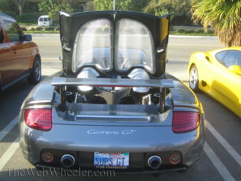 1985 Ford Mustang - A silver convertible is parked at a car show, its trunk open, with a yellow car visible to the right.