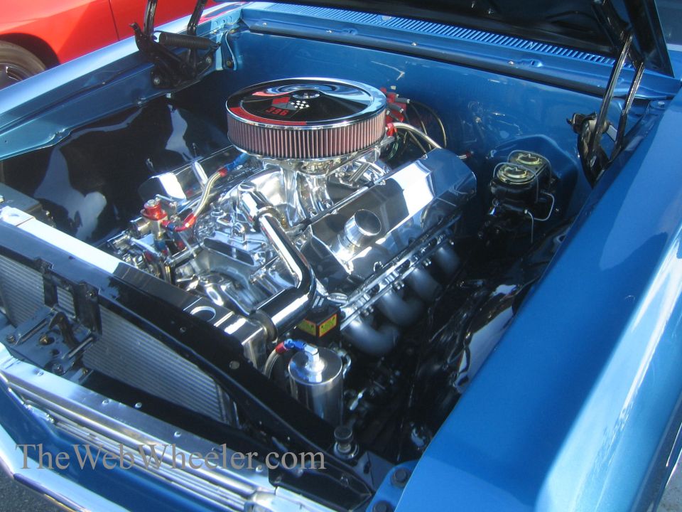 Blue car engine bay with chrome details and a V8 engine