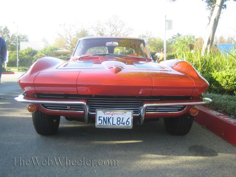 1985 Ford Mustang - A red 1963 Chevrolet Corvette Sting Ray coupe is parked outdoors, viewed from the front.