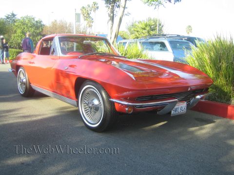 1985 Ford Mustang - Red 1963 Corvette Sting Ray coupe parked at a car show.