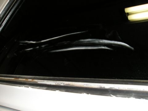 1993 Ford Bronco - Interior shot of a dark vehicle, showing a reflection on the window.