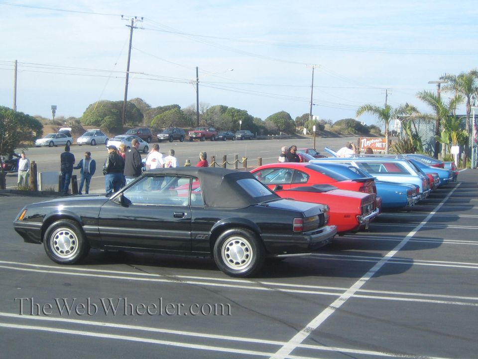 Black 1985 Ford Mustang GT convertible parked in a lot with other cars