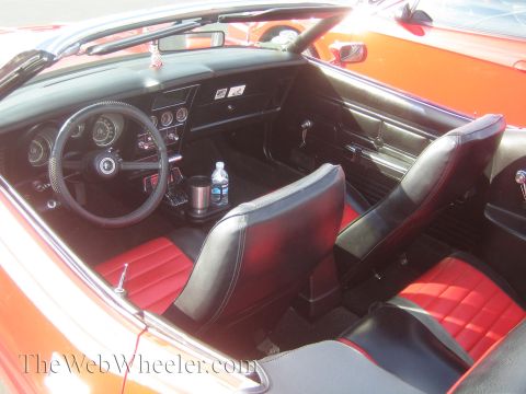 1985 Ford Mustang - Interior view of a classic red and black convertible, seen at a car show.