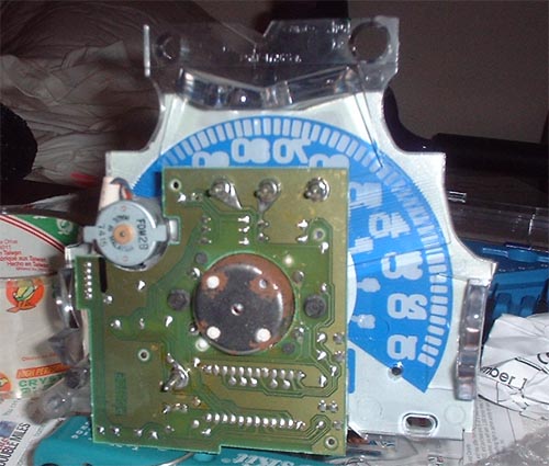 Close-up of a timing light with a circuit board and a blue dial with numbers