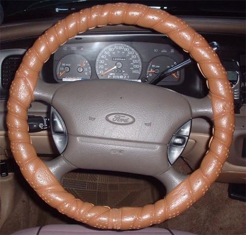 1997 Ford Crown Victoria - The interior of a 1997 Ford Crown Victoria features a brown steering wheel cover and a clear view of the dashboard gauges.
