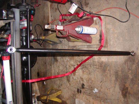 1991 Ford Bronco - A close-up view of an automotive suspension component with various tools and equipment in the background.