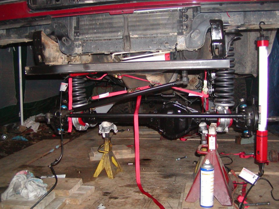 Vehicle underbody with suspension components, jack stands, and straps