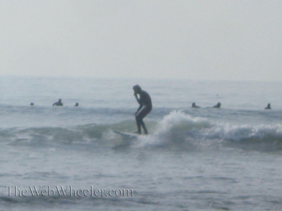 Surfer riding a wave with other people in the water