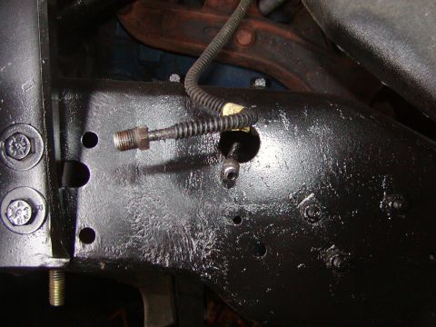 1991 Ford Bronco - Detail of a vehicle's frame showing brake line connections and mounting points.