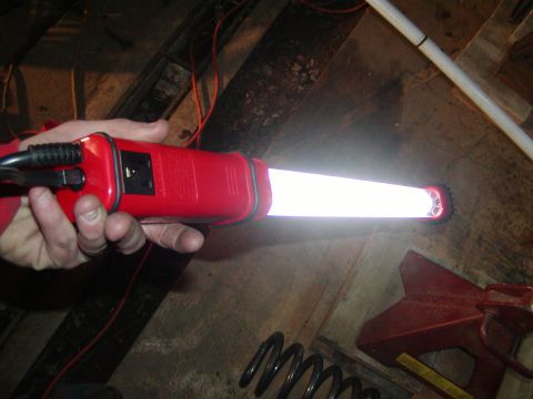 1991 Ford Bronco - A hand holds a red circuit tester, illuminating the area with its bright light.