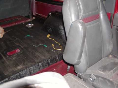 1991 Ford Bronco - Interior view of a vehicle showing gray seats, black flooring, and red accents. Wires are visible on the floor.