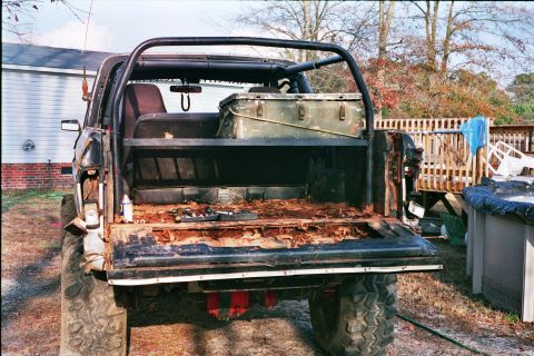 1978 Ford Bronco - The rear of a 1978 Ford Bronco shows significant rust and damage, with a toolbox visible in the cargo area.