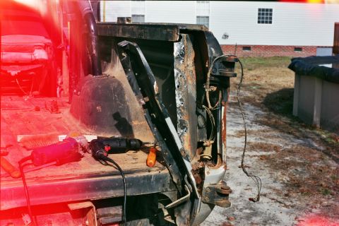 1978 Ford Bronco - Tools are laid out on the bed of a vehicle undergoing repair, focusing on the damaged rear tailgate.