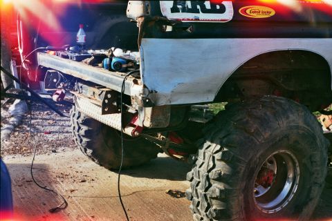 1978 Ford Bronco - Rear view of a 1978 Ford Bronco undergoing work, an ARB sticker and large off-road tires.