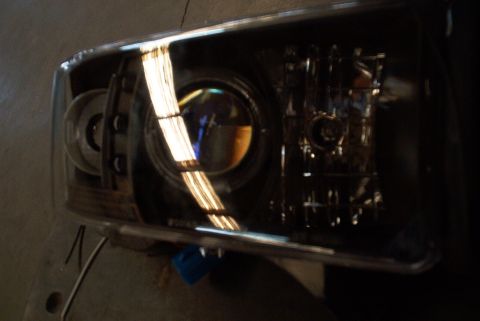 2001 Dodge 1500 - A single vehicle headlight assembly is shown, a projector lens and internal components.