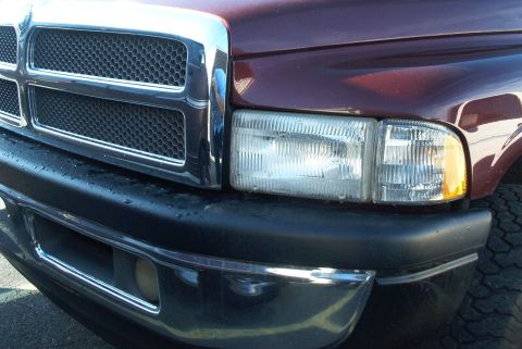2001 Dodge 1500 - Close-up of the front grille and headlight assembly on a maroon truck, identified as a 2001 Dodge 1500.