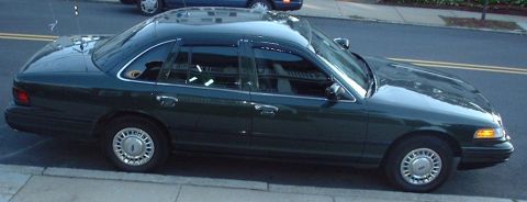 1997 Ford Crown Victoria - This dark green 1997 Ford Crown Victoria sedan is shown from the side.