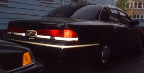 1997 Ford Crown Victoria - Rear view of a black 1997 Ford Crown Victoria parked beside another vehicle.