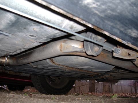 1998 Ford Taurus - The underside of a vehicle is visible, the exhaust pipe and suspension components.