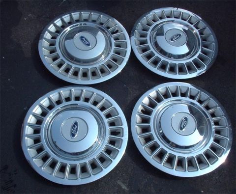 1997 Ford Crown Victoria - Set of four Ford hubcaps, likely for a sedan or coupe, the classic blue oval emblem.