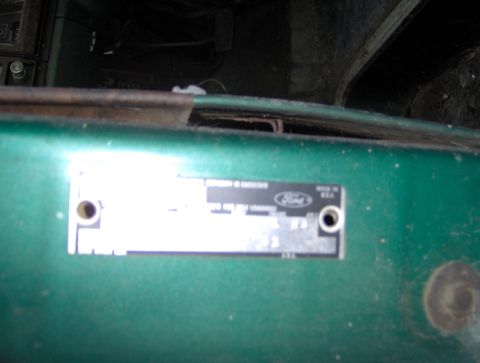 1978 Ford Bronco - A VIN plate is visible on the green painted surface of a vehicle.