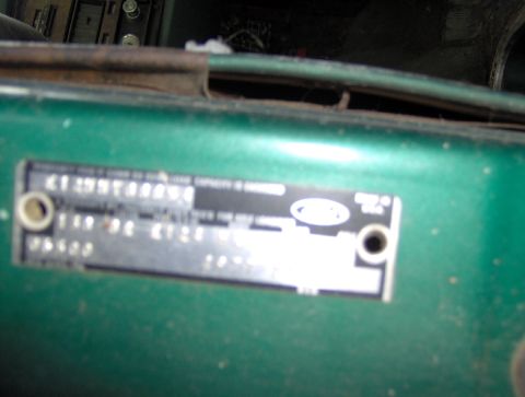 1978 Ford Bronco - A close-up of a green vehicle's VIN plate, showing the Ford logo and identifying information.