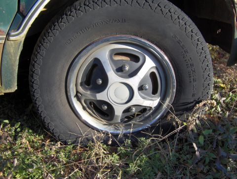 1978 Ford Bronco - Flat tire with Uniroyal branding visible on the sidewall.