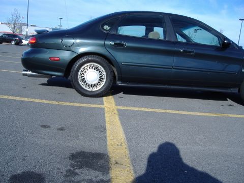 1998 Ford Taurus - Side view of a 1998 Ford Taurus sedan in a parking lot.