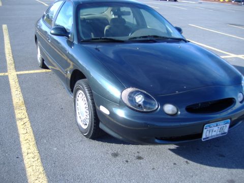 1998 Ford Taurus - This 1998 Ford Taurus is parked in a lot, showing its front quarter profile. The license plate is visible.