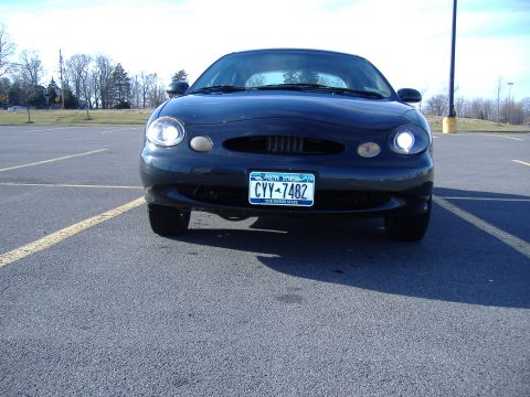 1998 Ford Taurus - Front view of a dark blue 1998 Ford Taurus parked in an asphalt lot under a clear sky.