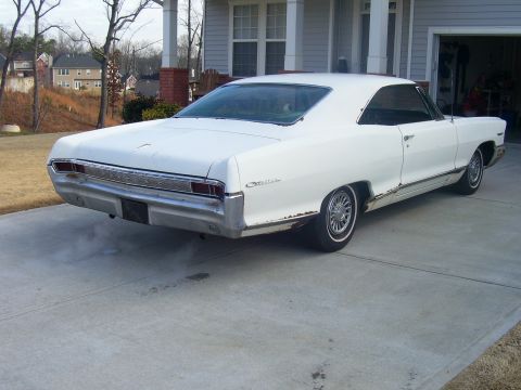 1965 Pontiac Catalina - Rear view of a white 1965 Pontiac Catalina with visible rust on the lower body panels.