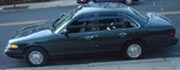 1997 Ford Crown Victoria - Side view of a dark green 1997 Ford Crown Victoria sedan parked on a street.