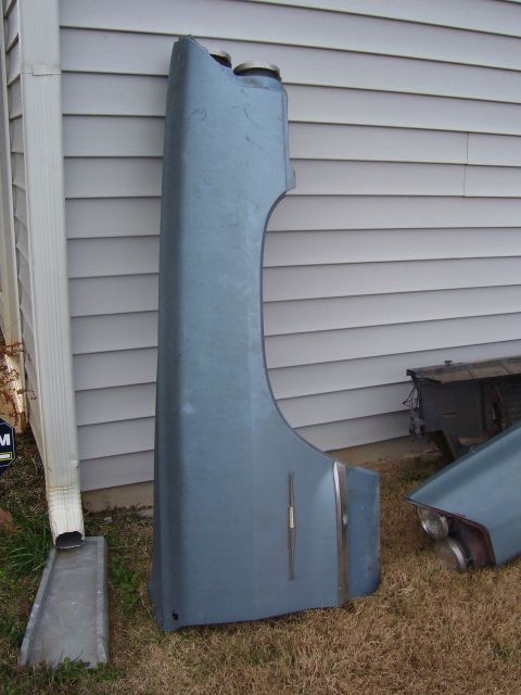 1965 Pontiac Catalina - A blue fender and taillight assembly from a 1965 Pontiac Catalina are shown next to a house.