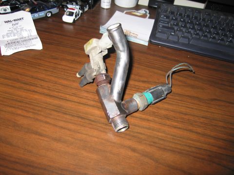 1991 Ford Crown Victoria LTD - A coolant sensor assembly with attached metal tubing and electrical connectors sits on a desk next to a Wal-Mart receipt.