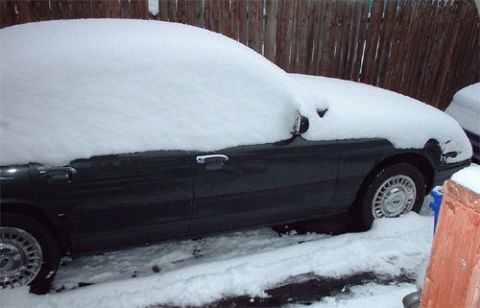 1997 Ford Crown Victoria - A 1997 Ford Crown Victoria sits covered in snow, parked outdoors.