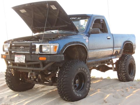 1977 Ford F-150 - Lifted blue Toyota pickup truck with its hood open, sitting on a sandy surface.